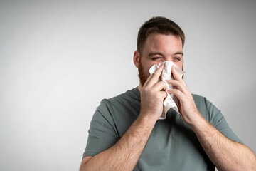 Sick, tissue and portrait of man blowing nose in studio with flu, illness and virus on white...