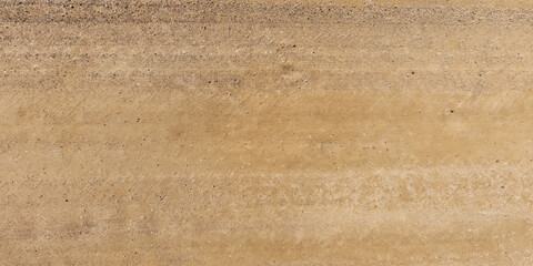 view from above on texture of dry road with tractor tire tracks in countryside.