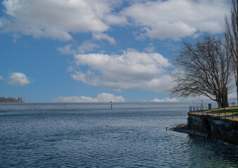 Calm waters and cloudy skies at lakeside park in early afternoon
