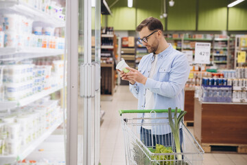 Customer Choosing Yogurt in Dairy Products Section of Supermarket