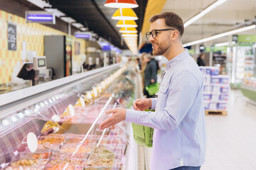 Customer choosing refrigerated food products at supermarket
