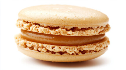 A macro shot of a French caramel macaron, highlighting its delicate texture against a crisp white background