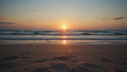 Obraz premium Golden Hour Seascape: Tranquil Waves Reflecting Sunset Hues on Sandy Shoreline