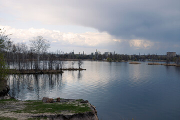 Tranquil scene of leafless white trees reflected in a still pond with a sand dune, creating a serene natural landscape