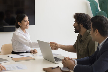 Indian female shaking hand Arabian colleague, greeting each other starting formal meeting,...
