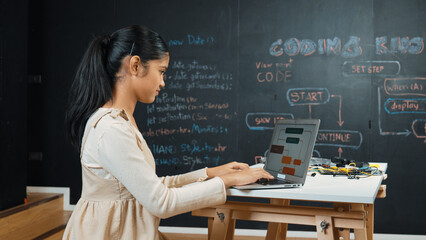 Highschool girl writing code or engineering prompt while attend in STEM technology class. Teenager...