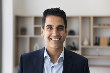 Goal-oriented successful mature Indian businessman dressed in jacket posing at workplace, looking...