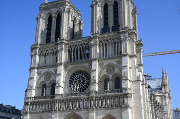 Fototapeta premium Notre-Dame Cathedral in Paris, France, with clear blue sky. Iconic Gothic architecture and historical landmark symbolizing culture, faith, and European heritage.