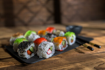 Sushi rolls served on a slate board in a cozy restaurant setting