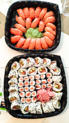 Delicious platters of fresh sushi and nigiri with wasabi and ginger displayed on table