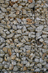 Close-up of a stone and iron mesh retaining wall, artificial retaining wall for crumbling hills 