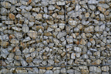 Close-up of a stone and iron mesh retaining wall, artificial retaining wall for crumbling hills 