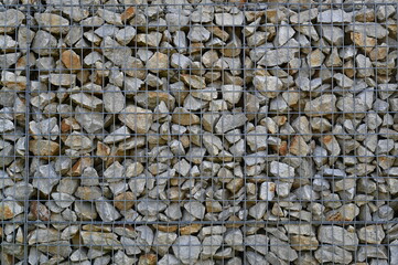 Close-up of a stone and iron mesh retaining wall, artificial retaining wall for crumbling hills 