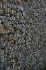 Close-up of a stone and iron mesh retaining wall, artificial retaining wall for crumbling hills 