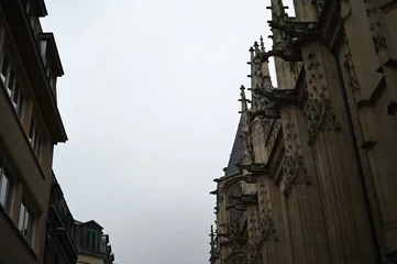 Fototapete Rund Enge Straßen Historic European city architecture with narrow streets and tall buildings under cloudy sky. Old town view — concept of travel, culture, urban lifestyle, and architectural heritage.  © Анна Климчук