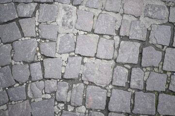 old grey paving stones for road surfaces, old cobblestones of the city of Rouen, gray paving slabs as a background, pavement paved slabs as a background