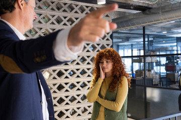 Manager dismissing employee in modern coworking space: unprofessional behavior
