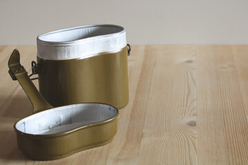 Military mess kit sitting on wooden table, ready for meal