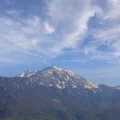 Fototapeta premium mountain ridge in snow under a blue cloudy sky