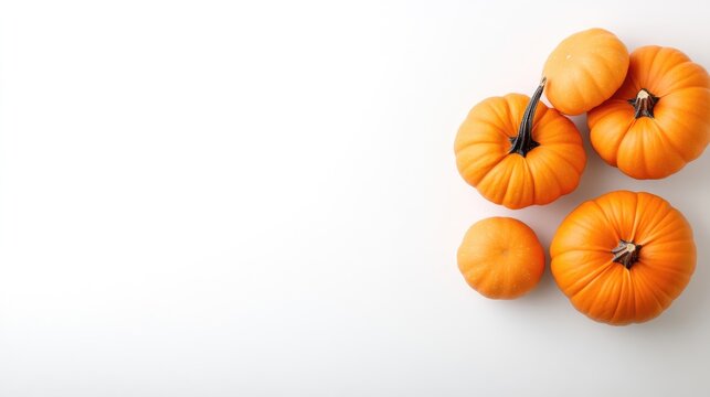 Fresh orange pumpkins grouped together on a clean white background, and minimalist composition for autumn harvest and Halloween decoration.