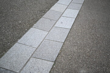 Urban sidewalk made of light gray paving slabs. Minimalistic street design with geometric concrete pattern. Ideal for architecture firms, landscape designers, construction companies, or background use