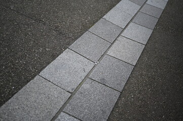 Urban sidewalk made of light gray paving slabs. Minimalistic street design with geometric concrete pattern. Ideal for architecture firms, landscape designers, construction companies, or background use