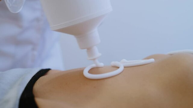 Close-Up of Masseur Applying Massage Cream to Clients Stomach