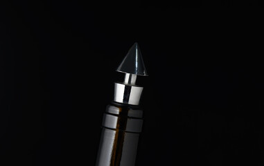 Elegant metallic pen tip shines against a dark background, showcasing exquisite craftsmanship and design in a close-up perspective