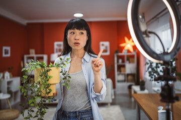 Japanese woman use mobile phone for live stream about home plants