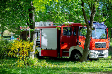 A Fire Truck is Parked in a Beautifully Lush Green Environment, Ready for Action