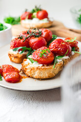 Bruschetta with cottage cheese, arugula and roasted cherry tomatoes. Food photo.