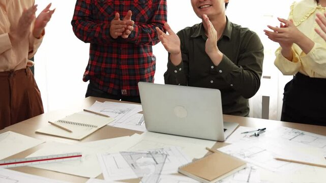 Architect and safety engineer celebrate success design building blueprint project on laptop with architectural document and measurement tool scatter around at modern office. Closeup. Delineation.