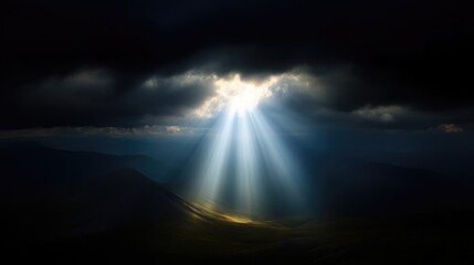 Sunlight piercing dark clouds over mountain range