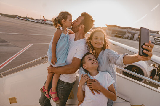 A joyful and excited family capturing a fun selfie together right before embarking on their flight journey