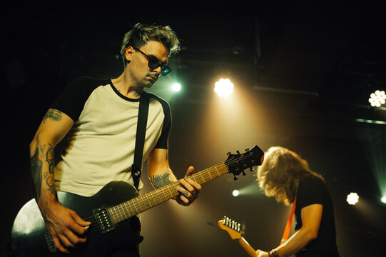 Guitarist playing electric guitar on stage during concert - Powered by Adobe