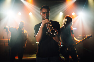 Trumpet player performing live on stage with band