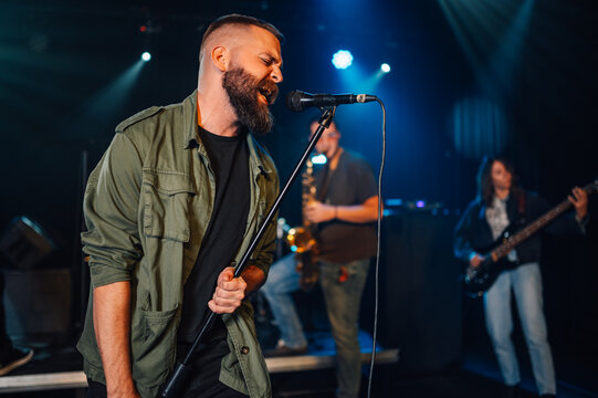 Singer performing with band on stage in nightclub