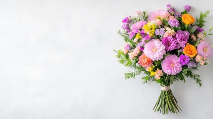 A vibrant bouquet of various flowers, including dahlias and carnations, is presented. The arrangement is tied with twine, sitting on a light gray background. The image is high quality with soft ligh