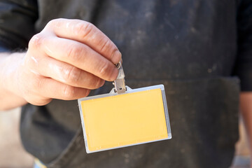 Construction worker wearing blank yellow identification badge, highlighting workplace safety, personnel identification, and secured access control protocols