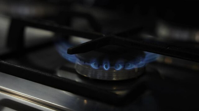 Turning on gas burner on stove, closeup