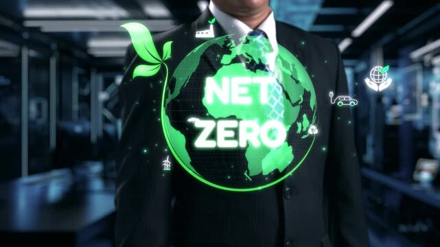 A businessman stands confidently in a suit with a digital display showcasing net zero goals, emphasizing sustainability, environmental responsibility, and innovative strategies. Qubit