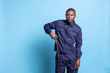 African american security guard preparing his baton in studio, getting ready for a fight to protect...