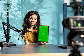 Tech specialist presenting mockup tablet to interested viewers, filming with professional mic and...