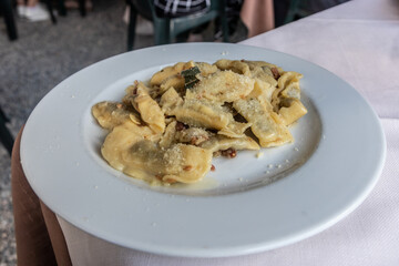 Typical dish of Bergamo - Casoncelli alla Bergamasca. Stuffed ravioli with Parmesan and bacon.