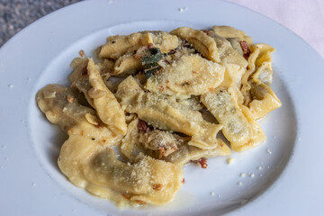 Typical dish of Bergamo - Casoncelli alla Bergamasca. Stuffed ravioli with Parmesan and bacon.