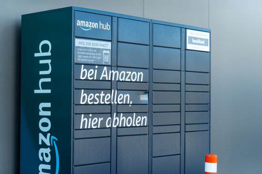 Amazon Hub parcel locker in Germany with text: "Bei Amazon bestellen, hier abholen." Self-service package pickup station for online orders, representing e-commerce and modern logistics.