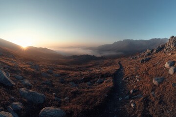Obraz premium A scenic pathway leading into a mountain landscape at sunrise
