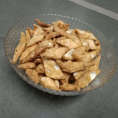 A bowl full of crunchy namak pare—savory, deep-fried flour crisps, perfect for tea-time snacking or festive occasions.