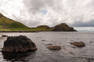 A rocky shoreline with a body of water in the background