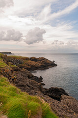 Naklejka premium A rocky shoreline with a cloudy sky in the background